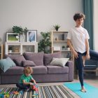 a woman standing in a living room next to a child