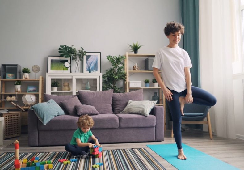 a woman standing in a living room next to a child